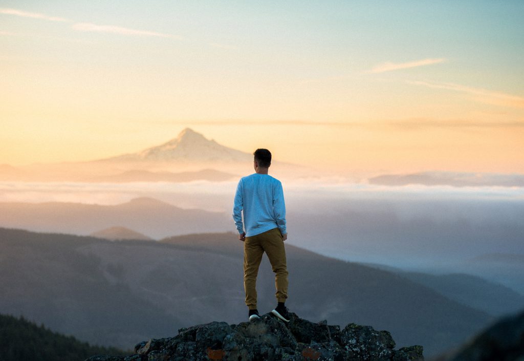 hombre exitoso en la cima de la montaña